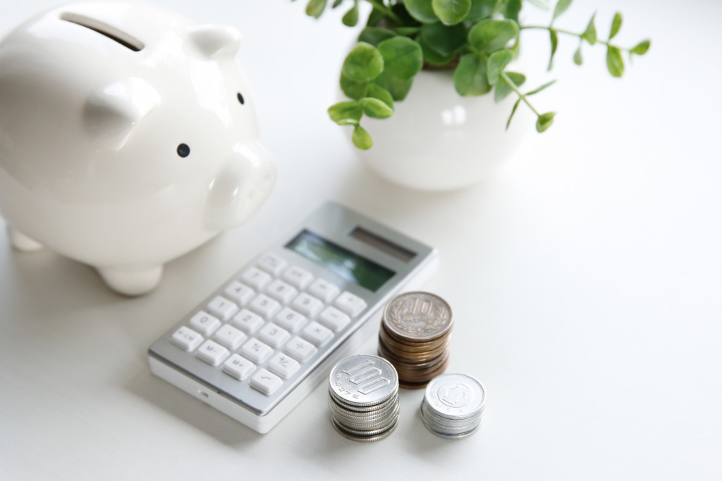 white piggybank, calculator, and coins