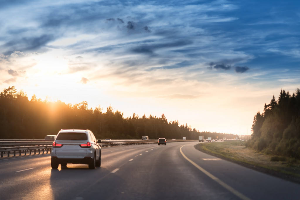 an suv cruising down the highway during sunset