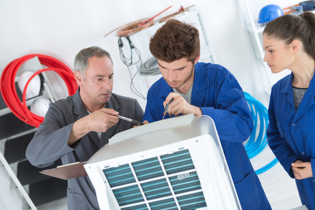 man inspecting an AC