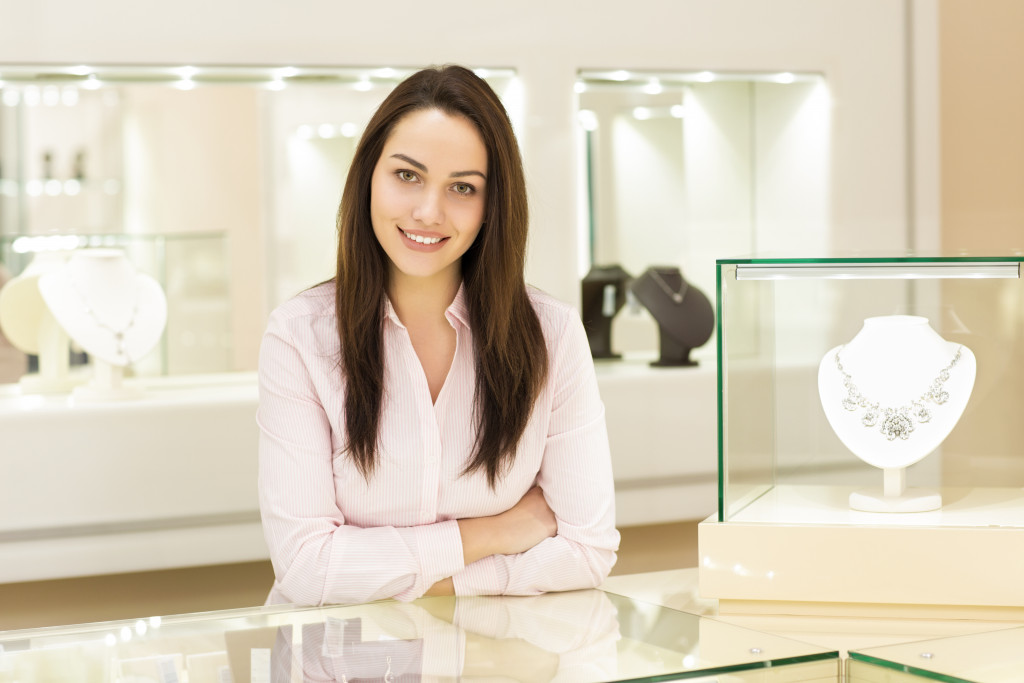 Store owner standing behind the counter of her well-lighted jewelry store.