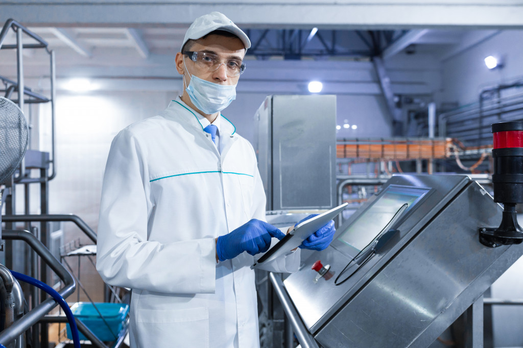 a man wearing a lab coat in a manufacturing plant for audit