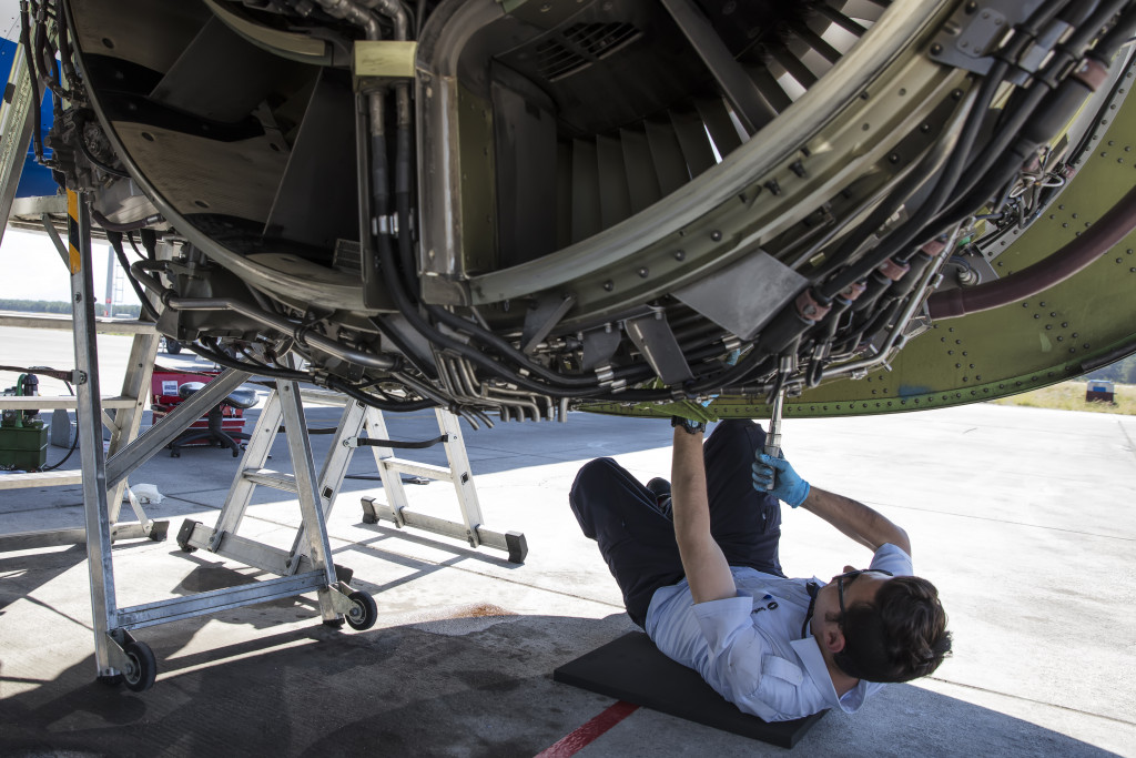 male maintenance worker checking the airplane's engine