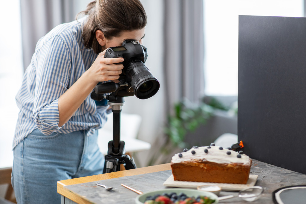 female food photographer taking photo of cake