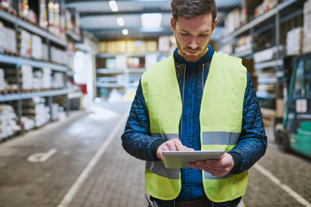 male inventory manager in the warehouse using tablet