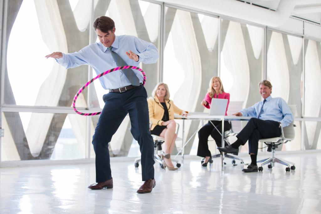 male employee doing hula hoop at work