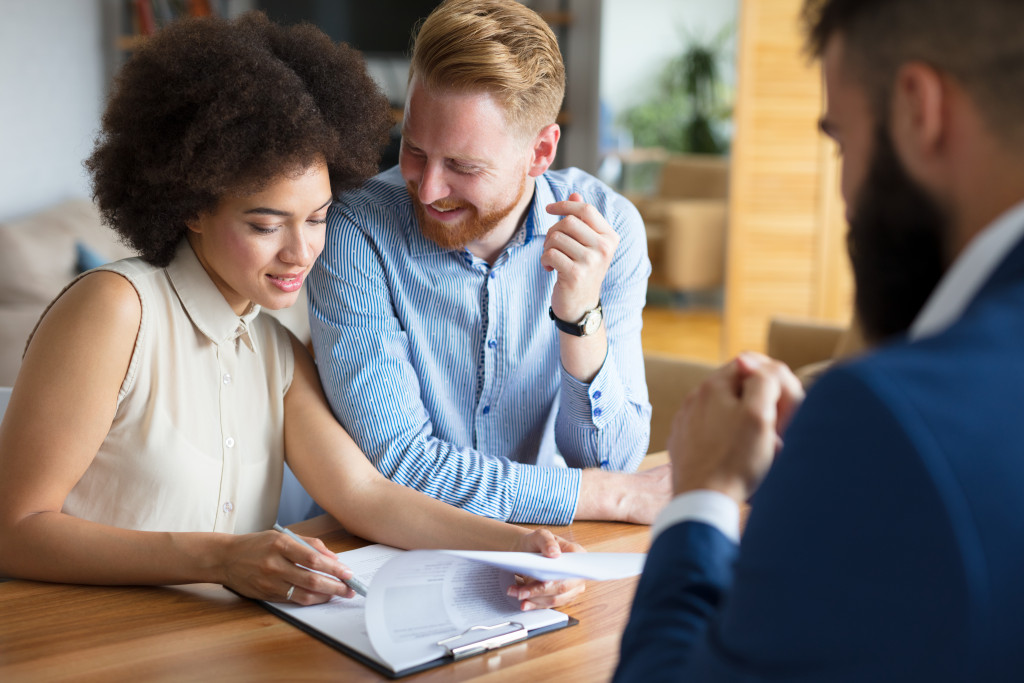 couple happily checking prenuptial agreements in the presence of a male attorney