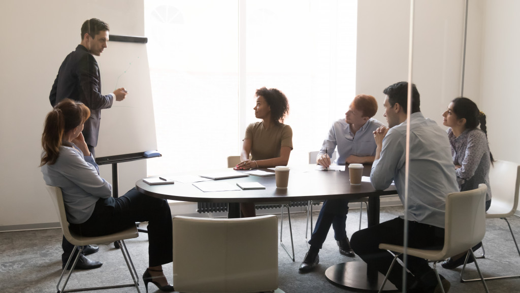 Employees listening to a man discussing something in an office