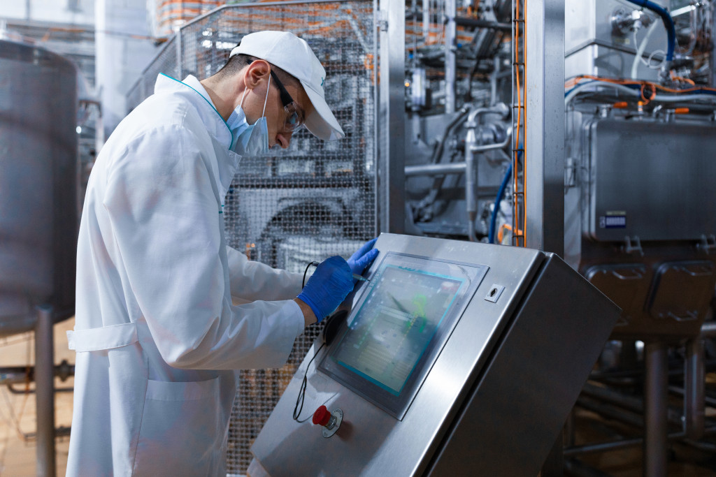 male worker with masks down checking diagnostics on an industrial equipment