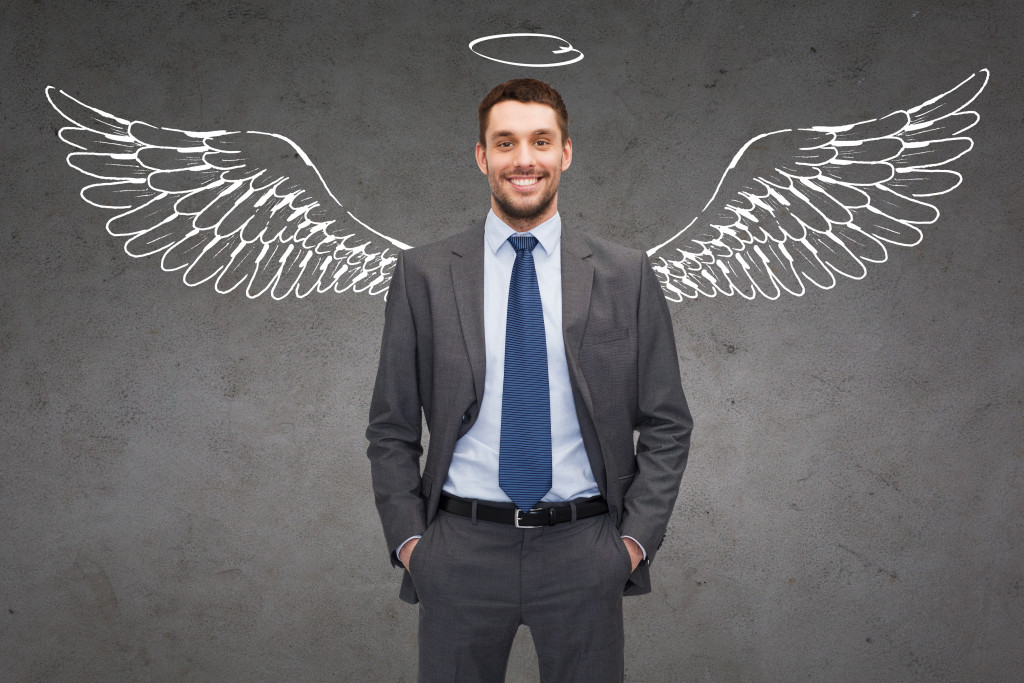businessman with graphic overlay of wings and halo to represent angel investment