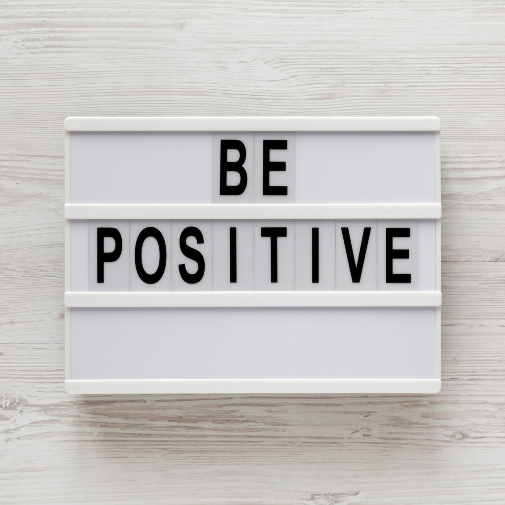 be positive word on lightbox against white wood background