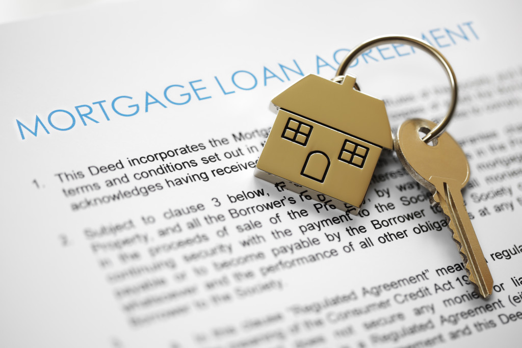 mortgage loan agreement document blurred with house key on top of it