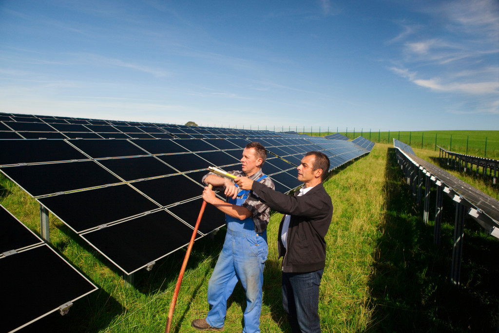 men after installing solar panels in the open field