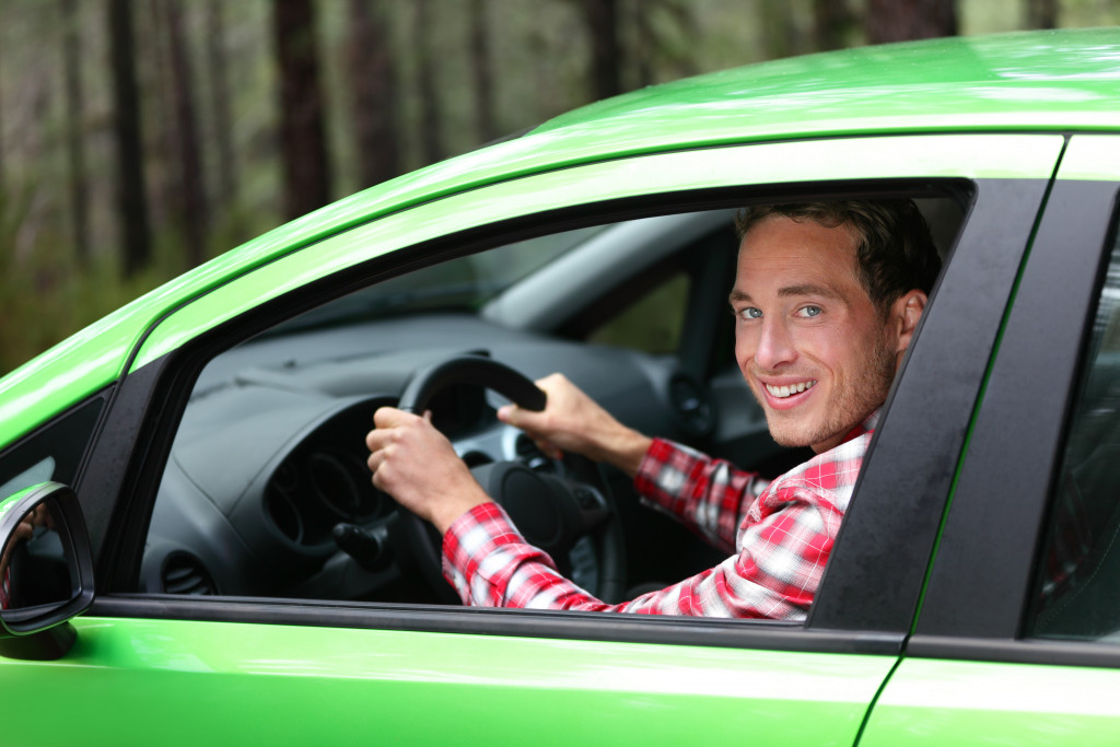 a man driving a green car