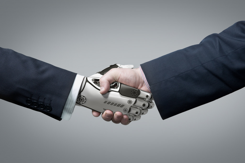 robot hands shaking hands with a businessman representing automation