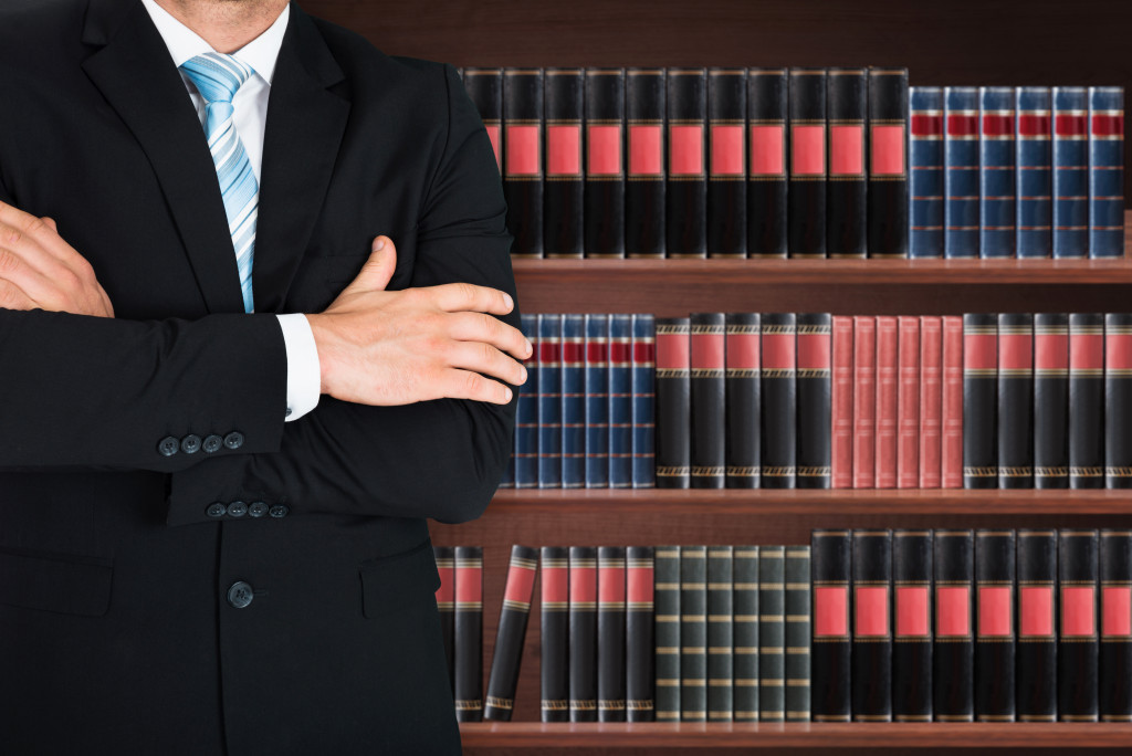 attorney with bookcase full of law books behind him